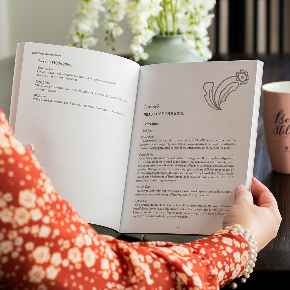 woman holding open BLAZE Belong leader's guide