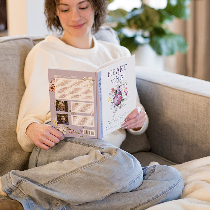 young woman holding Heart of Vines Book