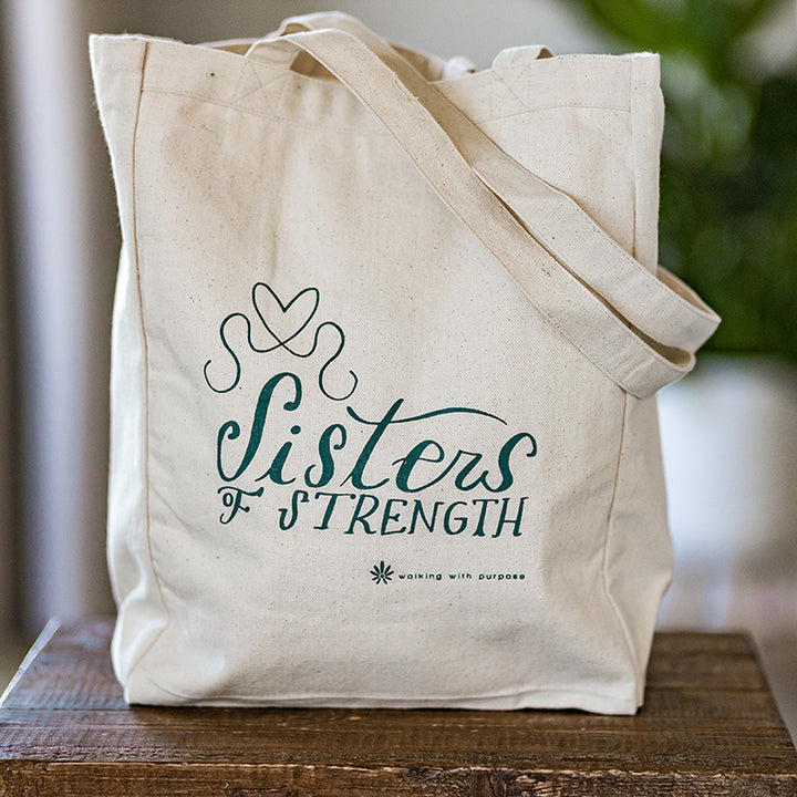 Sisters of strength tote bag on a table