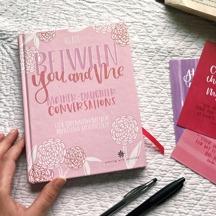 woman opening Between You and Me: Mother Daughter Journal and Devotional