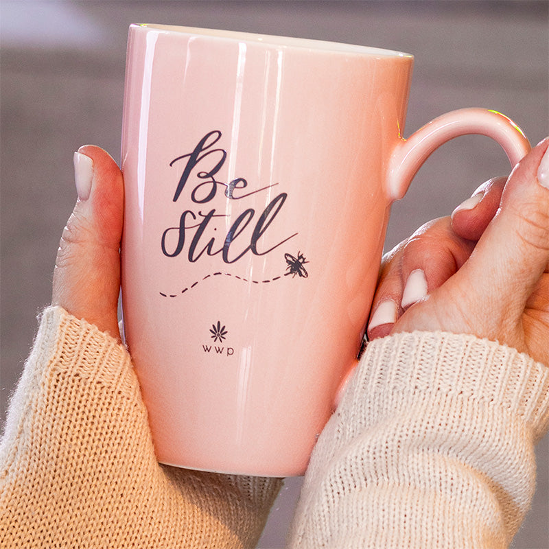 A woman holding a Light pink Be Still Tea Mug with Infuser and Lid