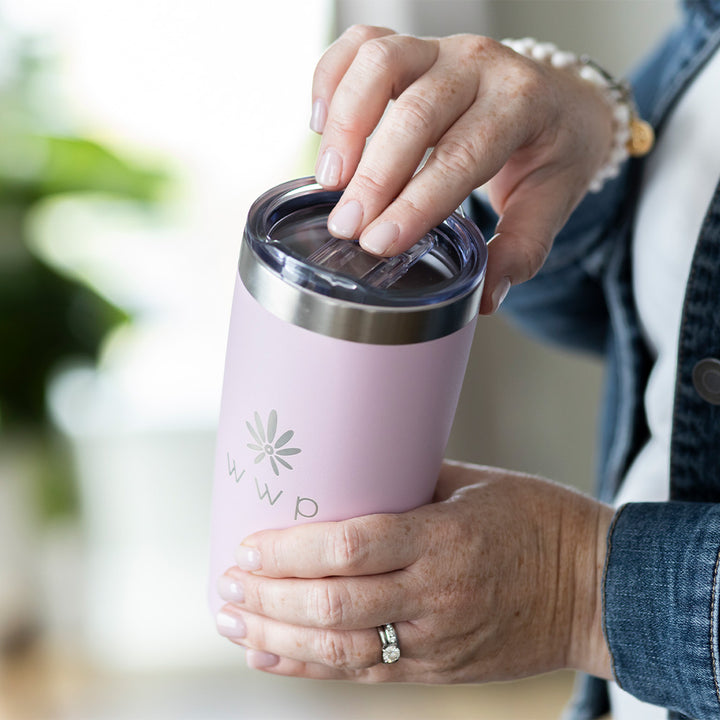 Pink tumbler with WWP flower logo with a woman demonstrating sliding the top to open